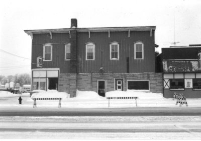 A black and white photo of a historic building after a snow storm