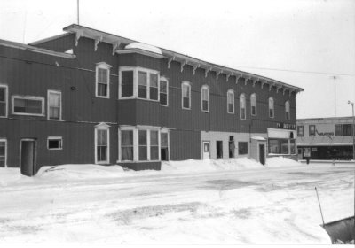 A black and white photo of a historic building after a snow storm
